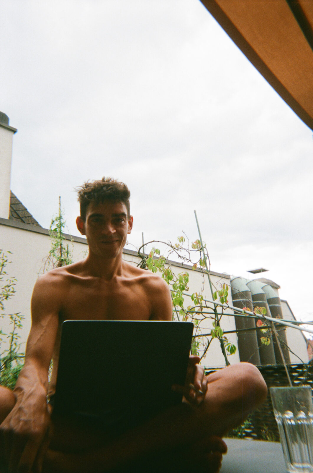 Josef Mohamed am Laptop auf einer Dachterrasse